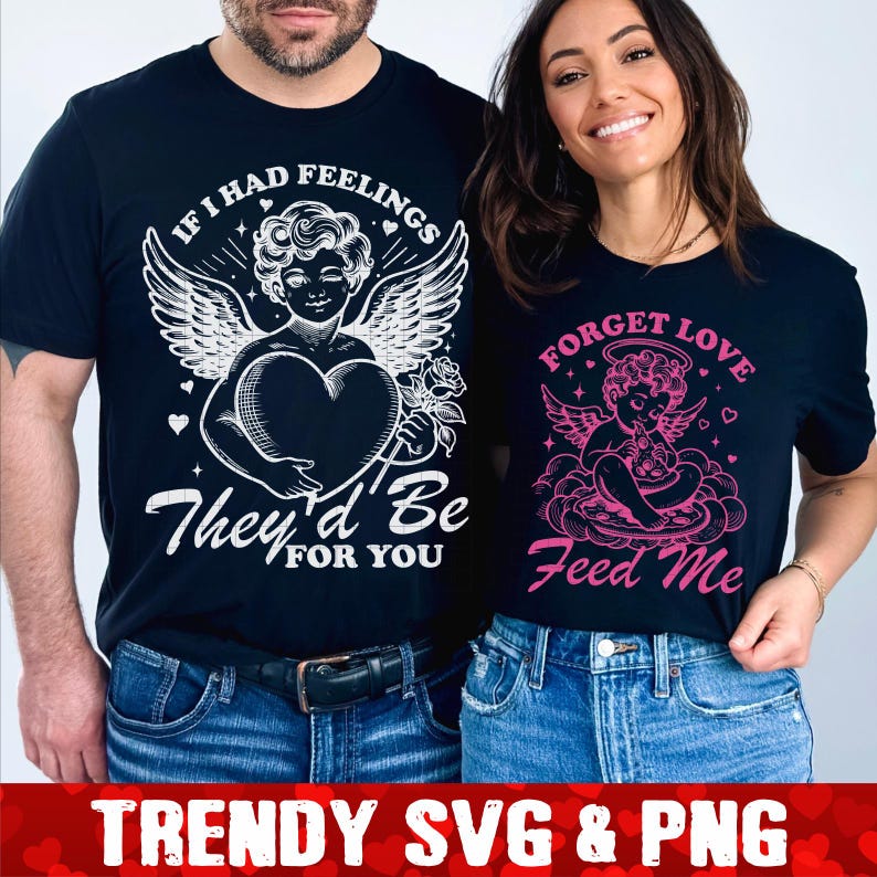 Op de afbeelding: Twee zwarte T-shirts met een witte en roze engel afbeelding. Het eerste shirt zegt "Als ik gevoelens had, zouden ze voor jou zijn". Het tweede shirt zegt "Vergeet liefde, voer me".