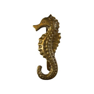 May include: A gold-colored metal seahorse hook. The seahorse is detailed with a textured, scaly design.