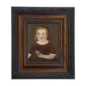 May include: A framed portrait of a child with curly hair, wearing a red and black plaid dress. The child is holding a small flower. The frame is dark brown with ornate detailing.