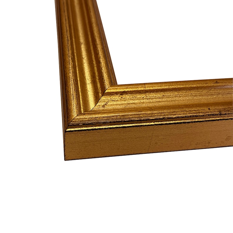May include: A close-up of a gold picture frame with a slightly distressed finish. The frame has a simple, elegant design with a slightly raised edge.