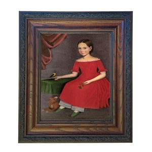 May include: A framed portrait of a young person in a red dress, seated with a small bird on a table. The painting features a teddy bear and a green table cloth. The frame is dark wood with ornate detailing.