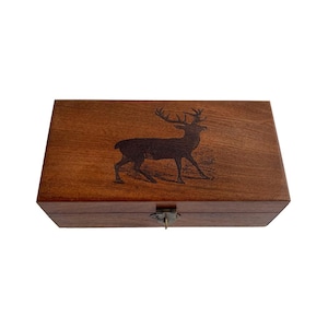 Op de afbeelding: Een houten doos met een scharnierend deksel en een messing sluiting. De bovenkant van de doos heeft een gegraveerd beeld van een hert met geweien.