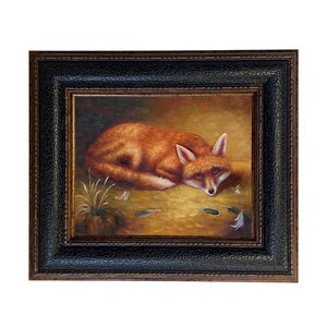May include: A framed painting depicts a resting fox with reddish-orange fur. The fox is lying down on a golden-yellow surface, surrounded by small details like leaves and feathers. The frame is black with a textured pattern.