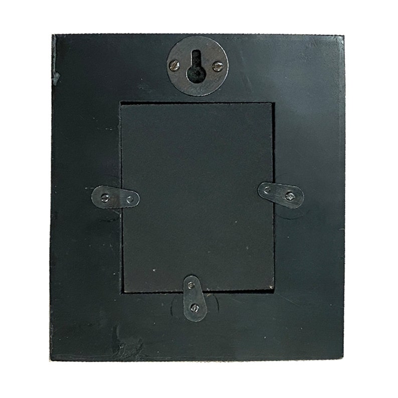 May include: Back of a square black picture frame with a centered rectangular opening. The frame has a metal hanger and metal clips to secure the backing. The frame is made of wood and has a slightly textured surface.