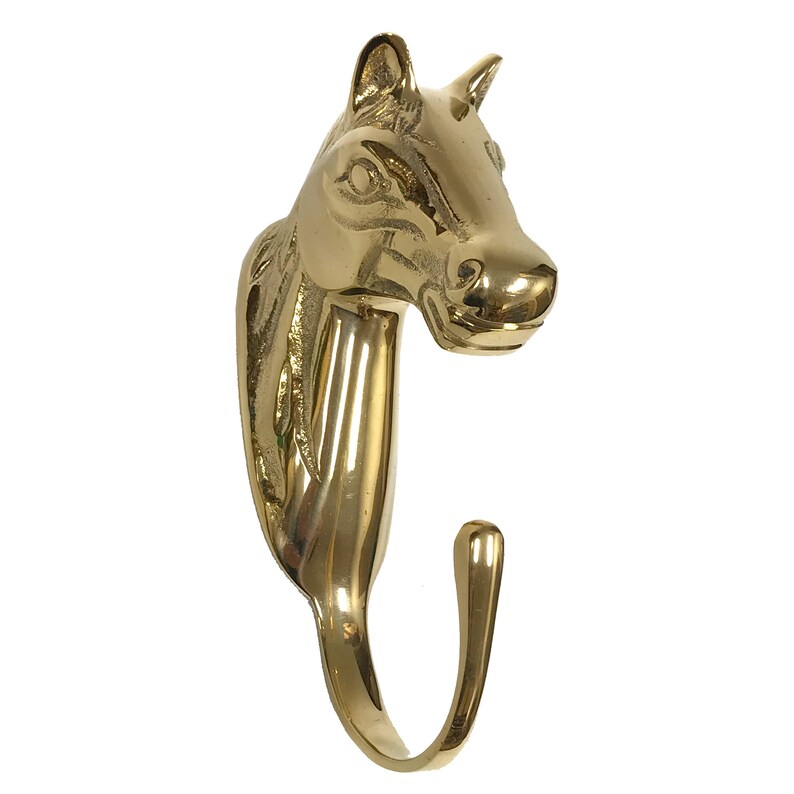 May include: A gold-toned horse head coat hook. The hook is shaped like a horse's head with a curved hook extending from the neck.