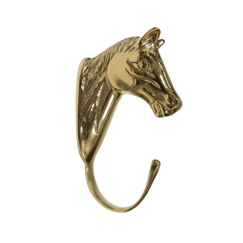 May include: A gold-toned metal horse head hook. The hook is shaped like a horse's head with a curved hook extending from the bottom.