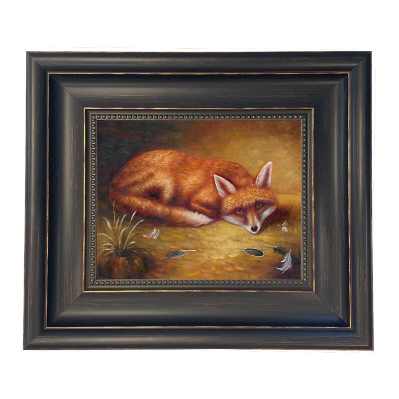 May include: A framed painting of a fox lying down, with orange fur and white accents. The artwork is set against a golden-brown background with small details of feathers and grass. The frame is dark brown with a decorative inner border.
