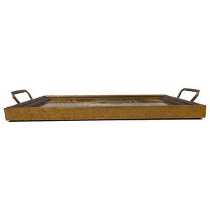 May include: A gold-colored serving tray with a dark wood frame and two brass handles. The tray has a distressed finish.