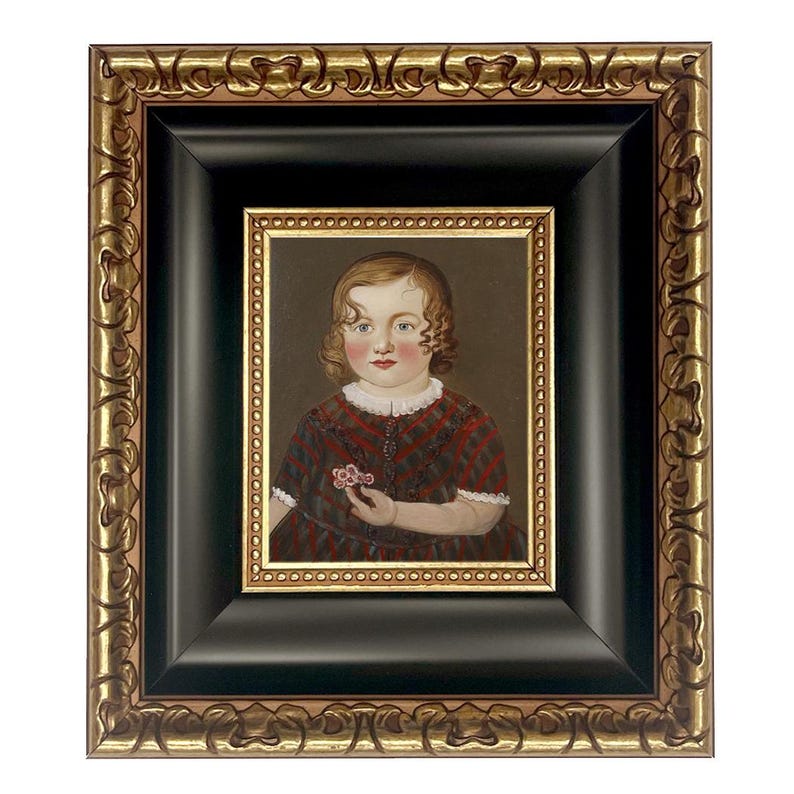 May include: An antique portrait of a child in a red and black plaid dress, holding a small flower. The painting is framed in a black frame with a gold ornate border, creating a vintage aesthetic.