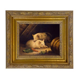 May include: A framed oil painting depicts two pigs in a barn setting. One pig is lying down, while the other stands behind it. A carrot, a turnip, and a leaf are in the foreground. The frame is gold-colored with a decorative leaf pattern.