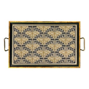 May include: Rectangular serving tray with a gold frame and handles. The tray's interior features a repeating geometric pattern in black, beige, and gold. The handles are a dark brass color, and the frame has a black border.