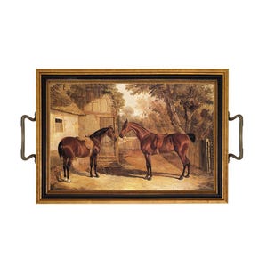 May include: A rectangular serving tray with a gold and black frame and two metal handles. The center features a detailed painting of two brown horses standing in a rural courtyard with a stone building, trees, and a wooden fence in the background.