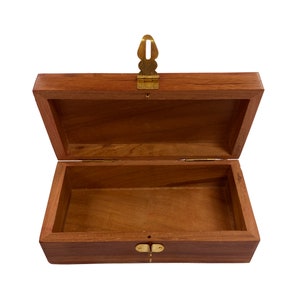 May include: A wooden box with a brass latch. The box is open and empty.