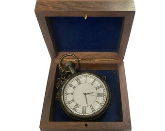 May include: A vintage-style pocket watch with Roman numeral markings on the face, a chain, and a brass finish. The watch is in a wooden box with a blue velvet lining.
