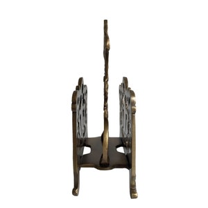 May include: A brass-colored metal letter holder with an ornate, openwork design. The holder has a central vertical support and two side compartments, each with a decorative, curved top. The overall design is vintage and elegant.