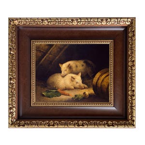 May include: A framed painting depicts two light-colored pigs in a barn setting. One pig is lying down, while the other is standing behind it. A carrot and a few green leaves are visible in the foreground. The frame is dark brown with gold accents.