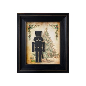 Puede incluir: Una silueta negra de un cascanueces se encuentra frente a una ilustración vintage de un árbol de Navidad. El cascanueces está enmarcado en un marco de madera negro con un borde dorado.