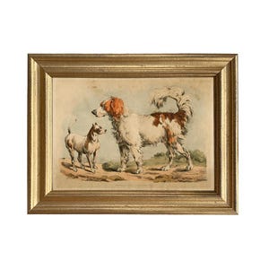 May include: A framed print of a vintage illustration of two dogs. The larger dog is white with brown markings and has its tail curled over its back. The smaller dog is white with black markings and is standing to the left of the larger dog. The print is framed in a gold frame.
