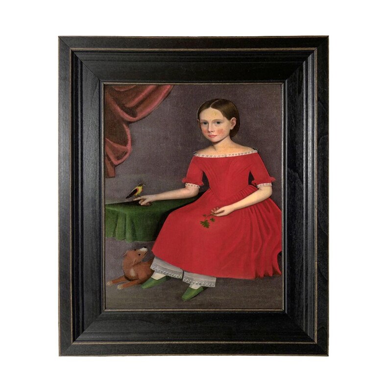 May include: Framed folk art portrait of a young person in a red dress, seated with a bird on a table and a stuffed animal. The painting has a dark wooden frame and a vintage aesthetic.
