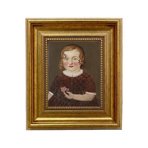 May include: A framed portrait of a young child. The child is wearing a red and black plaid dress and holding a small flower. The portrait is in a gold-colored frame.