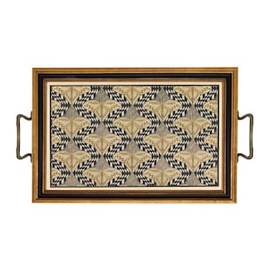 May include: Rectangular serving tray with a gold and black frame, featuring a geometric pattern in beige, black, and white. The tray has brass handles on each side, offering a stylish and functional design for serving.