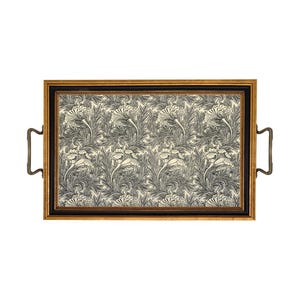 May include: A rectangular serving tray featuring a repeating black and cream floral botanical pattern. The tray is enclosed in a dark frame with a gold-toned outer border and includes two curved metal handles attached to the side edges.