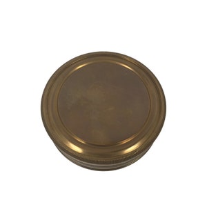 Puede incluir: Una br&uacute;jula redonda de lat&oacute;n antiguo con borde estriado. La br&uacute;jula tiene un dise&ntilde;o circular y un acabado pulido, lo que sugiere un tema vintage o n&aacute;utico. El lat&oacute;n tiene un tono dorado c&aacute;lido.