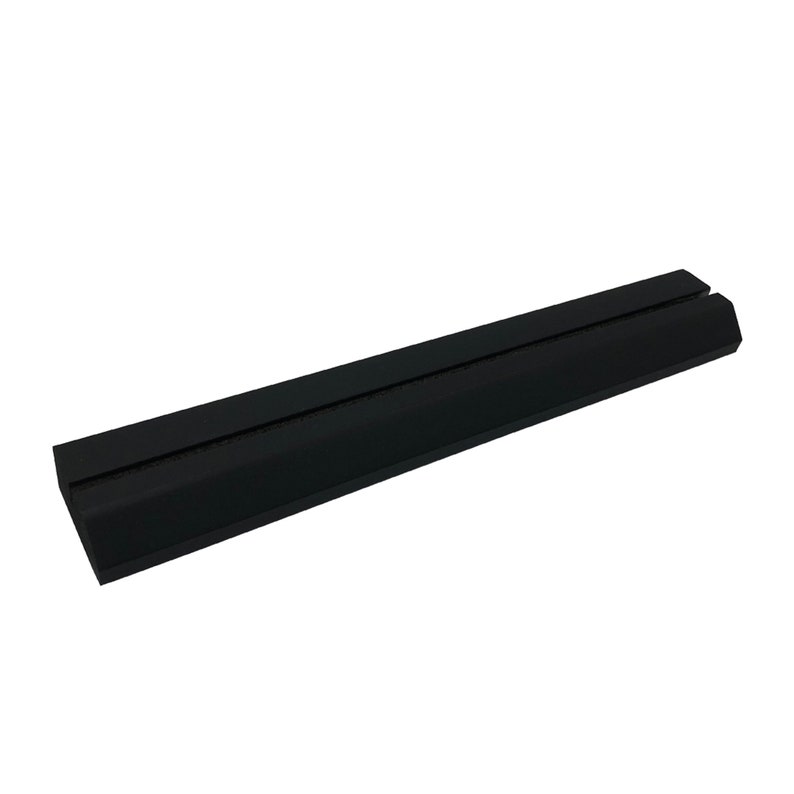 May include: Black rubber phone stand with a raised center ridge. The stand is designed to hold a phone upright.