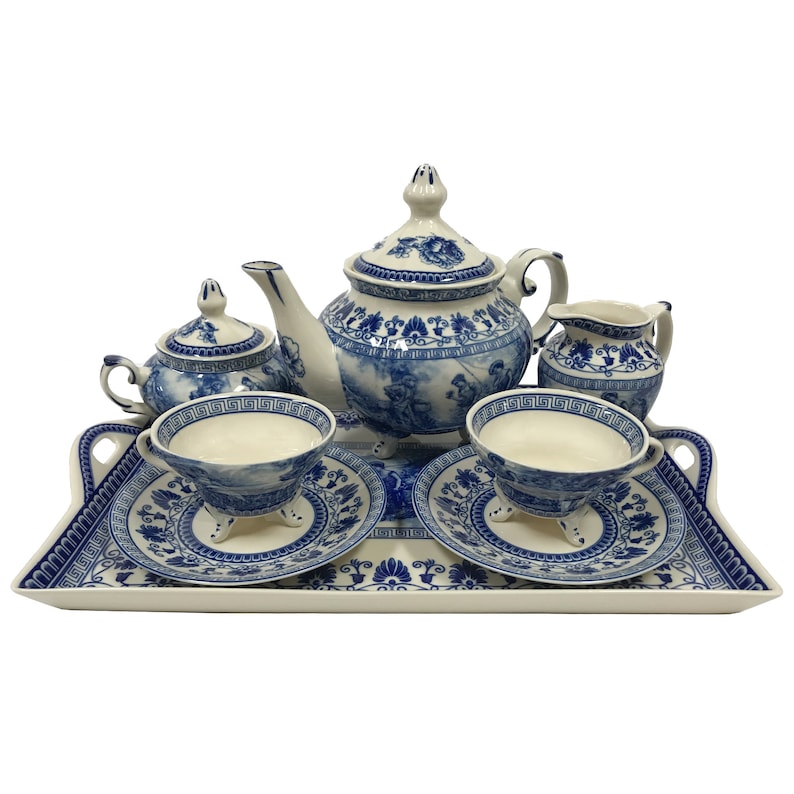 May include: A blue and white porcelain tea set with a teapot, creamer, sugar bowl, two cups and saucers, and a tray. The set features a floral design with blue accents.