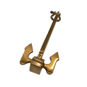 Puede incluir: Un ancla de metal dorado con un anillo en la parte superior. El ancla es un artículo decorativo y no está diseñada para su uso en el agua.