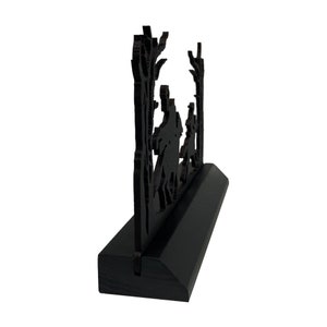 May include: Black wooden silhouette of three people walking through a forest. The silhouette is mounted on a black wooden base.