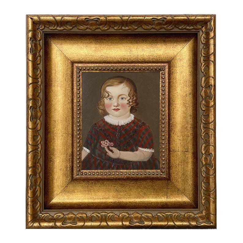 May include: An antique portrait of a child in a gold ornate frame. The child is wearing a red and black plaid dress and holding a small pink flower. The frame has a gold finish with detailed carvings.