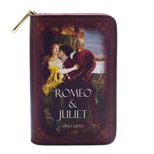 May include: A burgundy-coloured, rectangular zipped wallet featuring the Romeo & Juliet book cover art. The cover shows a romantic scene with the title text in white. A gold-coloured zip pull is visible.