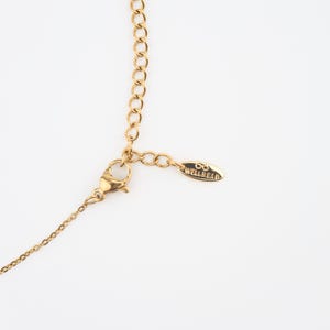 Peut inclure: Collier cha&icirc;ne en or avec un fermoir &agrave; ressort et une petite &eacute;tiquette en or qui indique "WELL READ" avec un symbole d'infini.