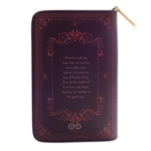 May include: A dark purple zippered pouch with a gold zip pull. The pouch has a textured leather-like appearance and features ornate red floral designs and text from a poem. The bottom of the pouch has the letters "WR" inside of a circle.