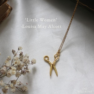 Peut inclure: Un collier en or avec un pendentif en forme de ciseaux. Le collier est sur un fond blanc avec une citation du livre 'Les Quatre Filles du Docteur March' de Louisa May Alcott.