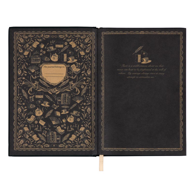 May include: Open journal with black pages and a gold-colored decorative border. The left page has a gold pattern of books, teacups, and other objects. The right page has text in gold. A cream-colored ribbon bookmark is visible.