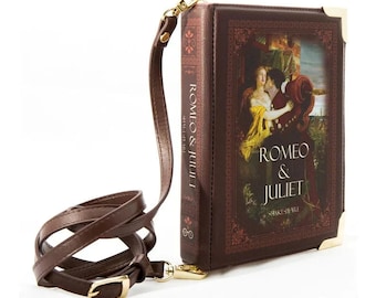 May include: A brown leather book-shaped purse with a gold clasp and a long brown strap. The front of the purse features a painting of Romeo and Juliet with the title "Romeo & Juliet" and the author "Shakespeare" printed below the image.