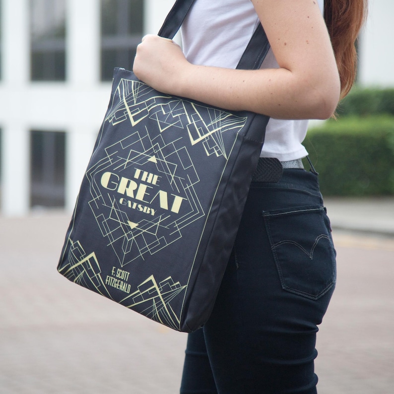 a woman carrying a black bag with a design on it