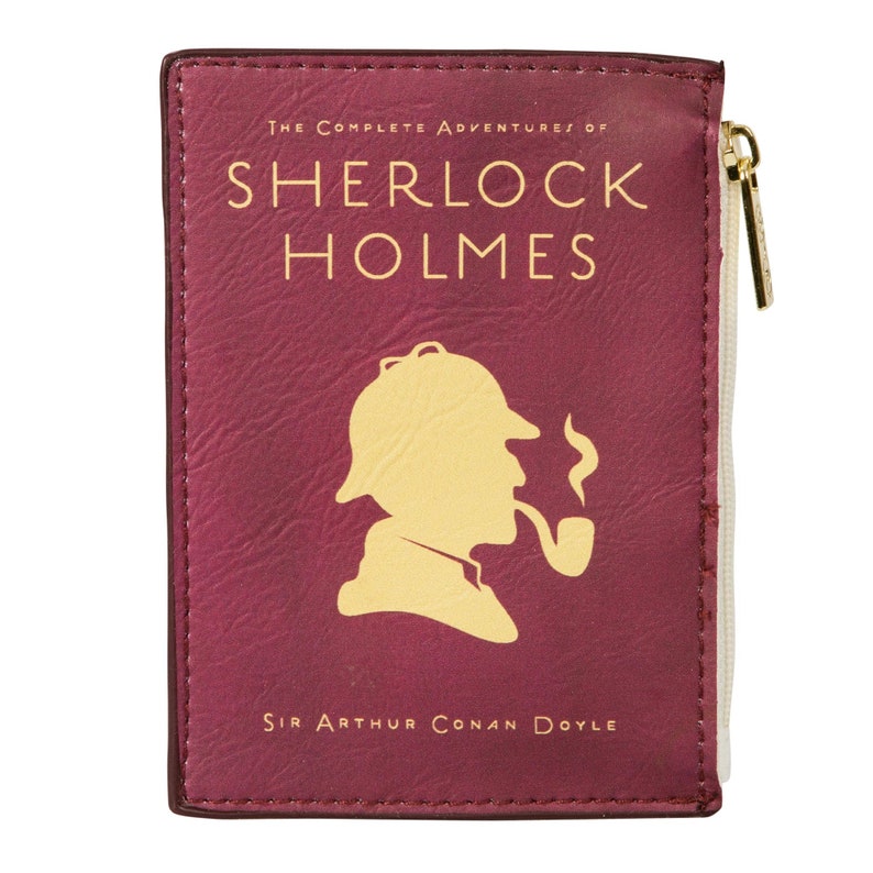Puede incluir: Una bolsa de cremallera color burdeos con una silueta de Sherlock Holmes con un sombrero de cazador y fumando una pipa. El texto "The Complete Adventures of Sherlock Holmes" y "Sir Arthur Conan Doyle" est&aacute; impreso en dorado en la parte delantera.