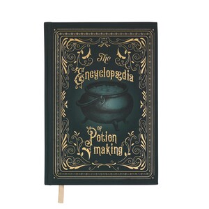May include: A dark green hardcover book titled "The Encyclopedia of Potion Making." The cover features a cauldron illustration and ornate gold-colored scrollwork. A cream-colored ribbon bookmark is visible.