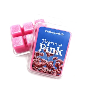May include: A package of pink wax melts from Westbury Candle Co. The label reads "Pretty in Pink" with a floral design. The wax melts are in a clear plastic container, with six individual cubes visible.
