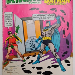 May include: A vintage comic book cover featuring Batman and Robin. The cover is predominantly pink with the title "Detective Comics" and the Batman logo. The artwork depicts Batman and Robin in action, with text bubbles and footprints. The comic is issue #364.
