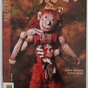 May include: The cover of "Animal Man" comic book features a doll-like figure with a bow, red hair, and a red outfit. The title is in orange letters. The comic is from DC Vertigo, issue #67, January 1994.