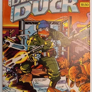Peut inclure: Une couverture de bande dessinée représentant un canard portant un chapeau bleu et tenant un fusil. Le canard se tient devant un bâtiment avec les mots "DESTROYER DUCK" en grandes lettres. La bande dessinée est intitulée "SPECIAL LAWSUIT BENEFIT EDITION #1" et coûte 1,50 €.