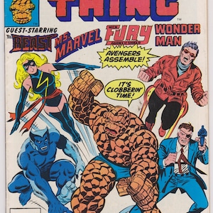 May include: A comic book cover featuring The Thing, Ms. Marvel, The Beast, and Wonder Man. The cover is orange, red, blue, and green. The title of the comic is "Marvel Two-In-One" featuring "The Thing". The tagline is "A Gathering of Heroes!"