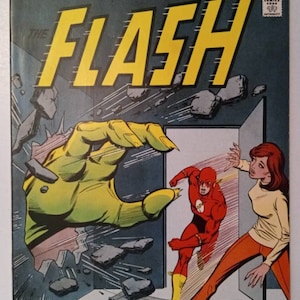 May include: A comic book cover featuring The Flash, a superhero in a red and yellow costume, running through a broken wall. The Flash is being pursued by a large, green hand. The cover also features the text "The Flash" and "The Line of DC Super-Stars".