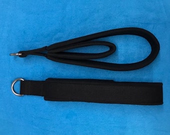 May include: Two black exercise straps with metal rings. One strap is a loop with a padded handle. The other strap is a flat strap with a padded section.