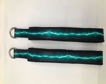 May include: Two black exercise straps with a teal lightning bolt design and silver metal rings.