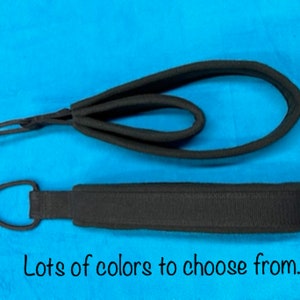 May include: Two black fabric wrist straps with a loop on one end and a hook on the other. Lots of colors to choose from.